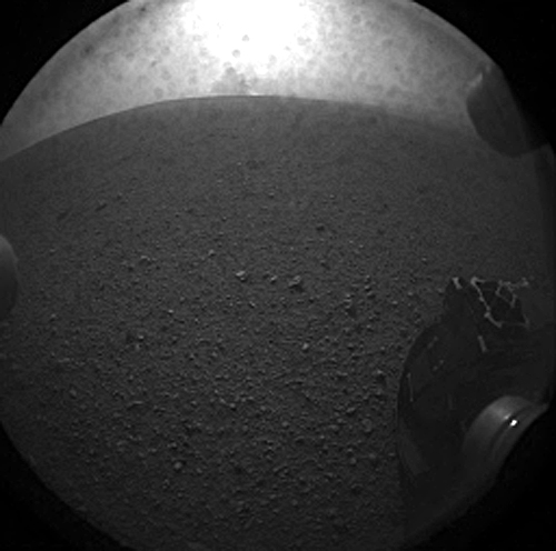 This is the first image taken by NASA's Curiosity rover, which landed on Mars the evening of Aug. 5 PDT (morning of Aug. 6 EDT). It was taken through a "fisheye" wide-angle lens on one of the rover's rear left Hazard-Avoidance cameras at one-quarter of full resolution. The clear dust cover on the camera is still on in this view, and dust can be seen around its edge, along with three cover fasteners. Credit: NASA/JPL-Caltech This is the first image taken by NASA's Curiosity rover, which landed on Mars the evening of Aug. 5 PDT (morning of Aug. 6 EDT). It was taken through a "fisheye" wide-angle lens on one of the rover's rear left Hazard-Avoidance cameras at one-quarter of full resolution. The clear dust cover on the camera is still on in this view, and dust can be seen around its edge, along with three cover fasteners. Credit: NASA/JPL-Caltech