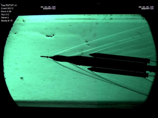 The 70-metric-ton configuration of the SLS rocket, designed to carry the Orion spacecraft, is tested in Marshall's Trisonic Wind Tunnel. This view uses special cameras and a deflection of light directed through the windows in the tunnel to show the shadows of airflow as it changes angles at high speeds, helping visualize the various intense pressures of atmosphere on the model. (NASA/MSFC) The 70-metric-ton configuration of the SLS rocket, designed to carry the Orion spacecraft, is tested in Marshall's Trisonic Wind Tunnel. This view uses special cameras and a deflection of light directed through the windows in the tunnel to show the shadows of airflow as it changes angles at high speeds, helping visualize the various intense pressures of atmosphere on the model. (NASA/MSFC)