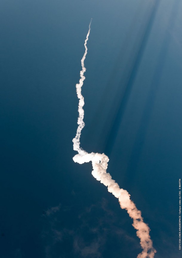 Ariane 5's climb-out from the Spaceport is traced by its plume, which is twisted by upper-level winds. At the plume's top, Ariane 5 is visible just after the jettison of its two solid propellant boosters. Ariane 5's climb-out from the Spaceport is traced by its plume, which is twisted by upper-level winds. At the plume's top, Ariane 5 is visible just after the jettison of its two solid propellant boosters.