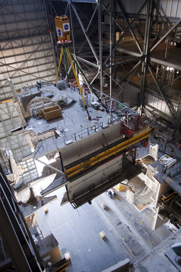 A large space shuttle-era work platform is being lowered by crane for removal from high bay 3 of the Vehicle Assembly Building. In order for platforms to be safely lowered to the floor, the center of gravity had to precisely determine for each of the seven sections. The work is part of a center-wide modernization and refurbishment initiative to accommodate NASA’s Space Launch System and a variety of other spacecraft instead of the whole building supporting one design. Photo credit: NASA/Jim Grossmann A large space shuttle-era work platform is being lowered by crane for removal from high bay 3 of the Vehicle Assembly Building. In order for platforms to be safely lowered to the floor, the center of gravity had to precisely determine for each of the seven sections. The work is part of a center-wide modernization and refurbishment initiative to accommodate NASA’s Space Launch System and a variety of other spacecraft instead of the whole building supporting one design. Photo credit: NASA/Jim Grossmann