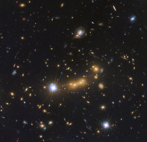 In this image, astronomers use NASA's Hubble Space Telescope and a cosmic zoom lens to uncover the farthest known galaxy in the universe. Observations from NASA's Spitzer Space Telescope helped confirm the finding. Image credit: NASA/ESA/STScI/CLASH In this image, astronomers use NASA's Hubble Space Telescope and a cosmic zoom lens to uncover the farthest known galaxy in the universe. Observations from NASA's Spitzer Space Telescope helped confirm the finding. Image credit: NASA/ESA/STScI/CLASH