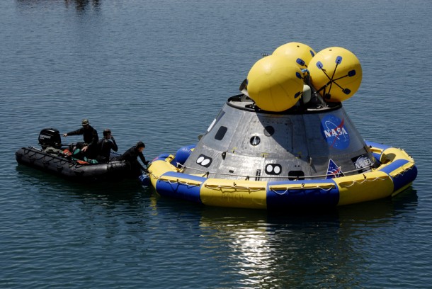 Members of the U.S. Air Force 920th Rescue Wing secure a flotation collar around the mockup Orion crew module at the Trident Basin at Port Canaveral, Fla. during testing in 2009. The post-landing Orion Recovery Test helped determine what kind of motion astronauts will experience after landing, as well as what recovery teams should expect. Photo credit: NASA/Kim Shiflett Members of the U.S. Air Force 920th Rescue Wing secure a flotation collar around the mockup Orion crew module at the Trident Basin at Port Canaveral, Fla. during testing in 2009. The post-landing Orion Recovery Test helped determine what kind of motion astronauts will experience after landing, as well as what recovery teams should expect. Photo credit: NASA/Kim Shiflett