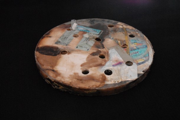 A disc produced by heating and compressing a sample of trash simulants. The discs are being tested for various conditions and the discs could be used in space to create radiation shields or for other tasks. Photo credit: NASA A disc produced by heating and compressing a sample of trash simulants. The discs are being tested for various conditions and the discs could be used in space to create radiation shields or for other tasks. Photo credit: NASA
