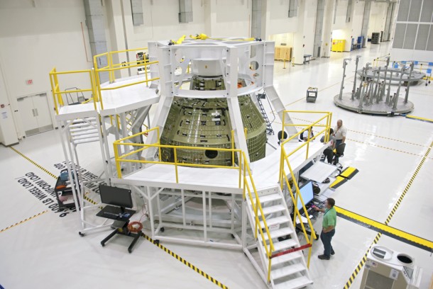 Inside the Operations and Checkout Building, a birdcage tool along with work platforms surround the Orion Exploration Flight Test 1 crew module. Image credit: NASA/Charisse Nahser Inside the Operations and Checkout Building, a birdcage tool along with work platforms surround the Orion Exploration Flight Test 1 crew module. Image credit: NASA/Charisse Nahser