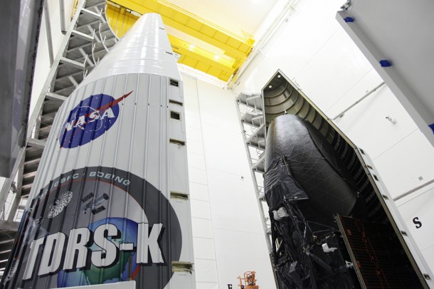 Inside the Astrotech payload processing facility near NASA's Kennedy Space Center in Florida, technicians move one half of the payload fairing into place over the Tracking and Data Relay Satellite, TDRS-K. Image credit: NASA/Frankie Martin Inside the Astrotech payload processing facility near NASA's Kennedy Space Center in Florida, technicians move one half of the payload fairing into place over the Tracking and Data Relay Satellite, TDRS-K. Image credit: NASA/Frankie Martin