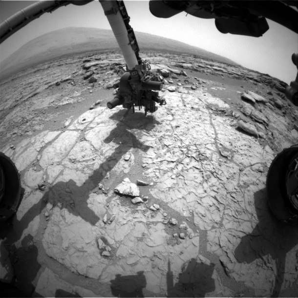 The percussion drill in the turret of tools at the end of the robotic arm of NASA's Mars rover Curiosity has been positioned in contact with the rock surface in this image from the rover's front Hazard-Avoidance Camera (Hazcam). Image Credit: NASA/JPL-Caltech The percussion drill in the turret of tools at the end of the robotic arm of NASA's Mars rover Curiosity has been positioned in contact with the rock surface in this image from the rover's front Hazard-Avoidance Camera (Hazcam). Image Credit: NASA/JPL-Caltech