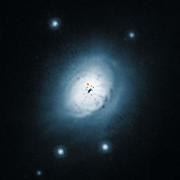 This image from the NASA/ESA Hubble Space Telescope shows a visible light view of the outer dust around the young star HD100546. The position of the newly discovered protoplanet is marked with an orange spot. The inner part of this picture is dominated by artifacts from the brilliant central star, which has been digitally subtracted, and the black blobs are not real. Credit: ESO/NASA/ESA/Ardila et al. This image from the NASA/ESA Hubble Space Telescope shows a visible light view of the outer dust around the young star HD100546. The position of the newly discovered protoplanet is marked with an orange spot. The inner part of this picture is dominated by artifacts from the brilliant central star, which has been digitally subtracted, and the black blobs are not real. Credit: ESO/NASA/ESA/Ardila et al.