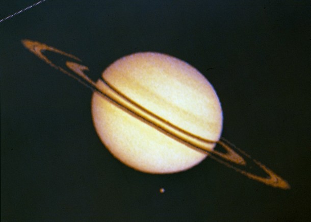 Saturn and its moon Titan at the upper left. The irregularities in ring silhouette and shadow are due to technical anomalies in the preliminary data later corrected. At the time this image was taken Pioneer was, at that time, 2,846,000 km (1,768,422 miles) from Saturn. Image credit: NASA Ames Saturn and its moon Titan at the upper left. The irregularities in ring silhouette and shadow are due to technical anomalies in the preliminary data later corrected. At the time this image was taken Pioneer was, at that time, 2,846,000 km (1,768,422 miles) from Saturn. Image credit: NASA Ames