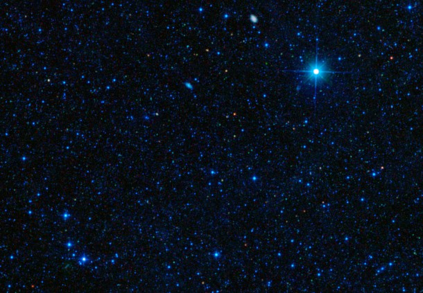 The tiny red spot in this image is one of the most efficient star-making galaxies ever observed, converting gas into stars at the maximum possible rate. The galaxy is shown here in an image from NASA's Wide-field Infrared Survey Explorer (WISE), which first spotted the rare galaxy in infrared light. Image credit: NASA/JPL-Caltech/STScI/IRAM The tiny red spot in this image is one of the most efficient star-making galaxies ever observed, converting gas into stars at the maximum possible rate. The galaxy is shown here in an image from NASA's Wide-field Infrared Survey Explorer (WISE), which first spotted the rare galaxy in infrared light. Image credit: NASA/JPL-Caltech/STScI/IRAM