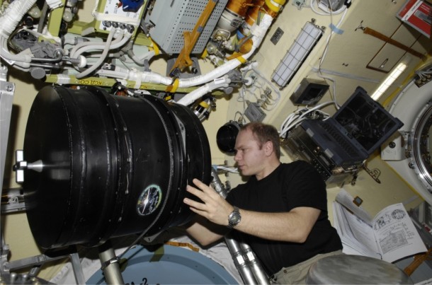 Russian cosmonaut Oleg Kononenko, Expedition 30 flight engineer, inspects the PK-3 Plus laboratory, enclosed in black housing, in its new home in the Poisk Mini-Research Module 2 of the International Space Station. Image Credit: RKK-Energia Russian cosmonaut Oleg Kononenko, Expedition 30 flight engineer, inspects the PK-3 Plus laboratory, enclosed in black housing, in its new home in the Poisk Mini-Research Module 2 of the International Space Station. Image Credit: RKK-Energia