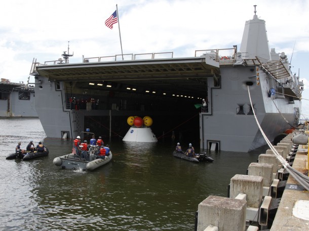 With the Orion test capsule in position over the recovery cradle, the water drained until the capsule settled. With the Orion test capsule in position over the recovery cradle, the water drained until the capsule settled.