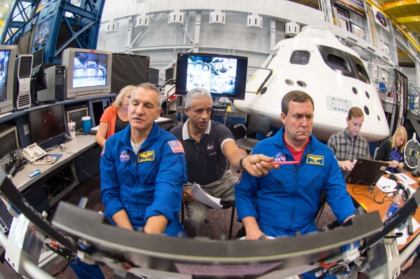 Astronauts Rick Linnehan and Mike Foreman work with simulation instructor Juan Garriga (center) to prepare for their first ascent simulation inside a mockup of NASA’s new Orion spacecraft at Johnson Space Center. Image Credit: NASA Astronauts Rick Linnehan and Mike Foreman work with simulation instructor Juan Garriga (center) to prepare for their first ascent simulation inside a mockup of NASA’s new Orion spacecraft at Johnson Space Center. Image Credit: NASA