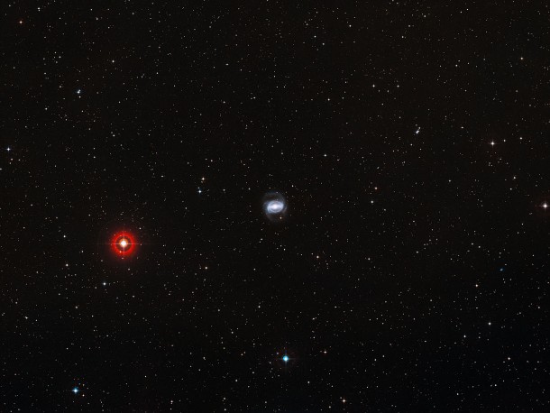 This wide-field image shows the patch of sky around the galaxy NGC 1433. This view was created from photographs forming part of the Digitized Sky Survey 2. The prominent red star to the left of the galaxy is HD 23719, which is just bright enough to be seen with the naked eye on a dark night. Credit: ESO/Digitized Sky Survey 2. Acknowledgement: Davide De Martin This wide-field image shows the patch of sky around the galaxy NGC 1433. This view was created from photographs forming part of the Digitized Sky Survey 2. The prominent red star to the left of the galaxy is HD 23719, which is just bright enough to be seen with the naked eye on a dark night. Credit: ESO/Digitized Sky Survey 2. Acknowledgement: Davide De Martin