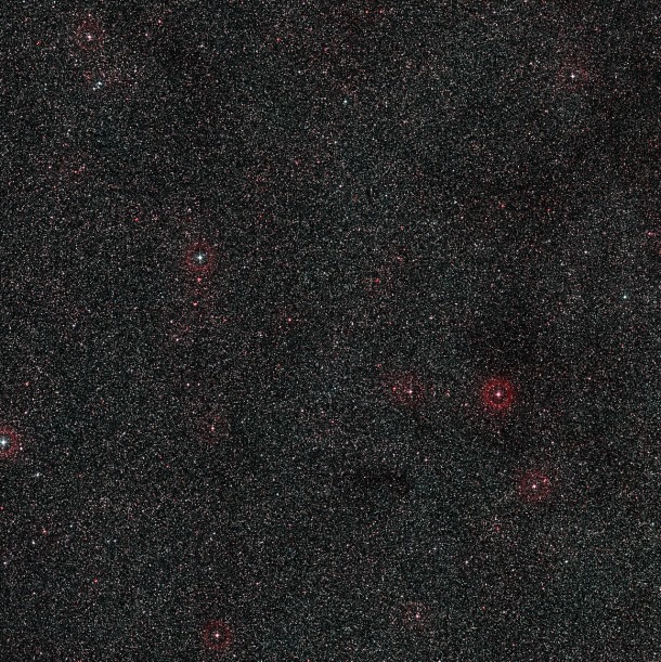 This wide-field image shows the patch of sky around the distant active galaxy PKS 1830-211. This view was created from photographs forming part of the Digitized Sky Survey 2. This part of the sky in the constellation of Sagittarius (The Archer) lies close to the central regions of the Milky Way and is very rich in stars. The remote galaxy lies at the centre of the picture, lost among the much closer stars of our own galaxy. Credit: ESO/Digitized Sky Survey 2. Acknowledgement: Davide De Martin This wide-field image shows the patch of sky around the distant active galaxy PKS 1830-211. This view was created from photographs forming part of the Digitized Sky Survey 2. This part of the sky in the constellation of Sagittarius (The Archer) lies close to the central regions of the Milky Way and is very rich in stars. The remote galaxy lies at the centre of the picture, lost among the much closer stars of our own galaxy. Credit: ESO/Digitized Sky Survey 2. Acknowledgement: Davide De Martin