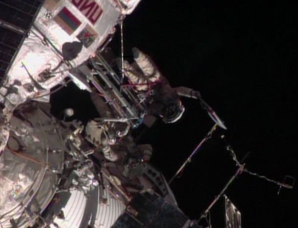 Flight Engineer Oleg Kotov waves the Olympic torch as Flight Engineer Sergey Ryazanskiy looks on during a spacewalk outside the International Space Station. Image Credit: NASA TV Flight Engineer Oleg Kotov waves the Olympic torch as Flight Engineer Sergey Ryazanskiy looks on during a spacewalk outside the International Space Station. Image Credit: NASA TV