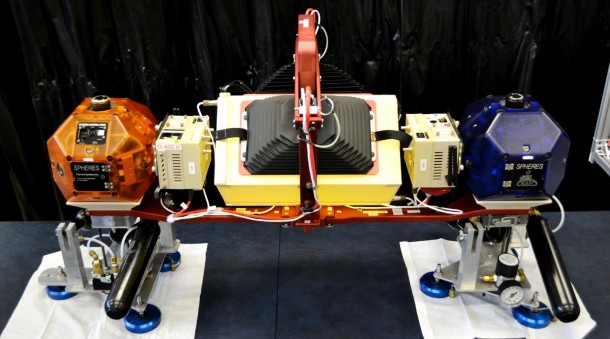 The SPHERES robots will be attached at opposite ends of a metal frame. In the center of the frame is a clear plastic 18-inch by eight-inch pill shaped tank that is partially filled with green colored water. A pair of high resolution cameras will record the movement of the liquid inside the tank as the experiment is pushed around by the SPHERES robots. Additionally, several inertial measurement units will accurately record the position of the experiment as it moves within the space station. Image Credit: Florida Institute of Technology/Dr. Daniel Kirk The SPHERES robots will be attached at opposite ends of a metal frame. In the center of the frame is a clear plastic 18-inch by eight-inch pill shaped tank that is partially filled with green colored water. A pair of high resolution cameras will record the movement of the liquid inside the tank as the experiment is pushed around by the SPHERES robots. Additionally, several inertial measurement units will accurately record the position of the experiment as it moves within the space station. Image Credit: Florida Institute of Technology/Dr. Daniel Kirk