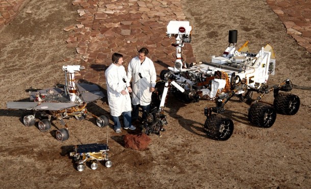 Spacecraft engineers Matt Robinson of NASA's Jet Propulsion Laboratory, left, and Wesley Kuykendall of the California Institute of Technology, stand with a group of vehicles providing a comparison of three generations of Mars rovers. Front and center is the flight spare for the first Mars Pathfinder rover, Sojourner, which landed on Mars in 1997. On the left is a Mars Exploration Rover test spacecraft, a working sibling to Spirit and Opportunity, which landed on Mars in 2004. On the right is the Curiosity Mars Science Laboratory test rover. MSL touched down on Mars Aug. 6, 2012. Image Credit: NASA/JPL-Caltech Spacecraft engineers Matt Robinson of NASA's Jet Propulsion Laboratory, left, and Wesley Kuykendall of the California Institute of Technology, stand with a group of vehicles providing a comparison of three generations of Mars rovers. Front and center is the flight spare for the first Mars Pathfinder rover, Sojourner, which landed on Mars in 1997. On the left is a Mars Exploration Rover test spacecraft, a working sibling to Spirit and Opportunity, which landed on Mars in 2004. On the right is the Curiosity Mars Science Laboratory test rover. MSL touched down on Mars Aug. 6, 2012. Image Credit: NASA/JPL-Caltech