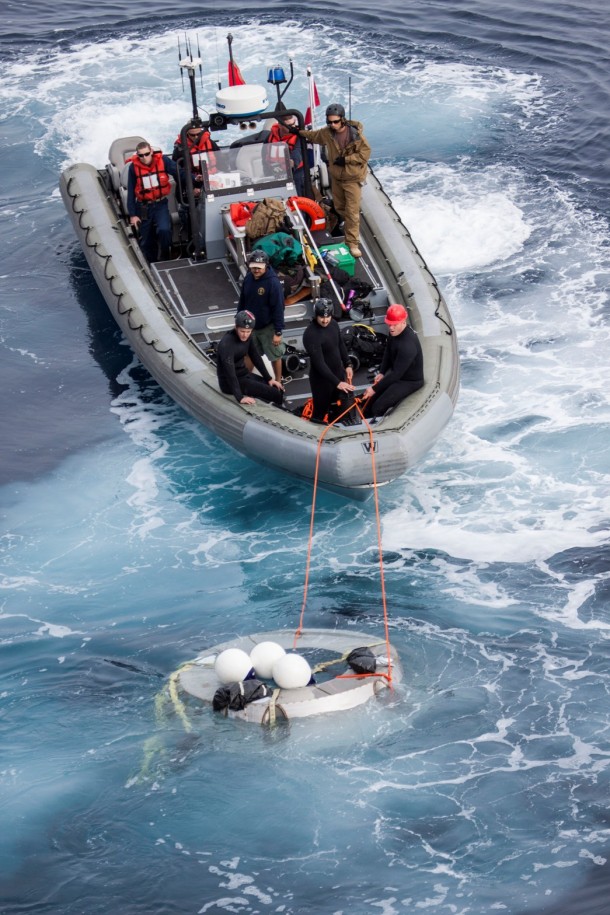 Members of the Orion recovery team work to retrieve a test version of Orion's forward bay cover, a protective shell that fits on the crew module, from the Pacific Ocean on Feb. 19. Members of the Orion recovery team work to retrieve a test version of Orion's forward bay cover, a protective shell that fits on the crew module, from the Pacific Ocean on Feb. 19.