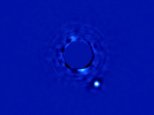 The Gemini Planet Imager captured this first light image of Beta Pictoris b, a planet orbiting the star Beta Pictoris. The star, Beta Pictoris, is blocked in this image by a mask so its light doesn't interfere with the light of the planet. The Gemini Planet Imager captured this first light image of Beta Pictoris b, a planet orbiting the star Beta Pictoris. The star, Beta Pictoris, is blocked in this image by a mask so its light doesn't interfere with the light of the planet.