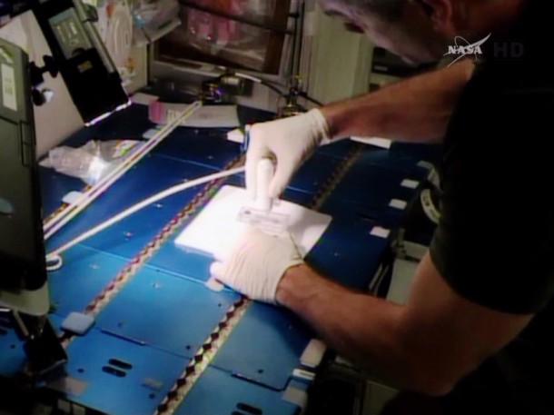 Commander Steve Swanson stirs an experiment sample with a magnet for the ACE investigation. Image Credit: NASA TV Commander Steve Swanson stirs an experiment sample with a magnet for the ACE investigation. Image Credit: NASA TV