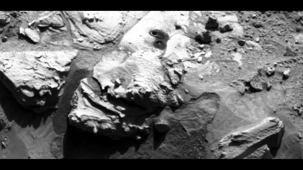 This May 5, 2014, image from the Navigation Camera on NASA's Curiosity Mars rover shows two holes at top center drilled into a sandstone target called "Windjana." The farther hole was created by the rover's drill while it collected rock-powder sample material from the interior of the rock. Image Credit: NASA/JPL-Caltech This May 5, 2014, image from the Navigation Camera on NASA's Curiosity Mars rover shows two holes at top center drilled into a sandstone target called "Windjana." The farther hole was created by the rover's drill while it collected rock-powder sample material from the interior of the rock. Image Credit: NASA/JPL-Caltech