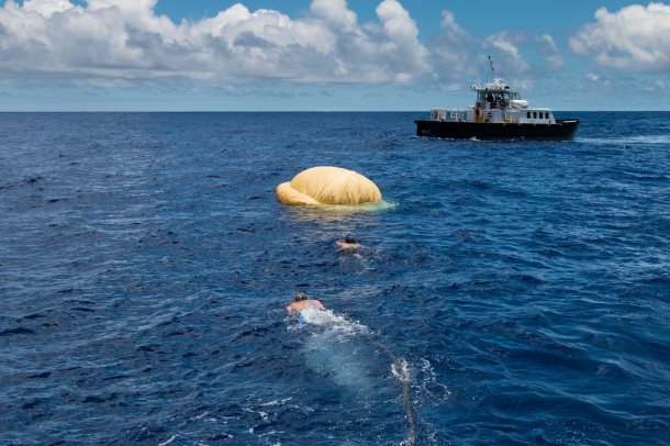 Hours after the June 28, 2014, test of NASA's Low-Density Supersonic Decelerator over the U.S. Navy's Pacific Missile Range, two members of the Navy's Explosive Ordinance Disposal swim towards the test vehicle. In the background, the recovery vessel Mana'o II. Image Credit: NASA/JPL-Caltech Hours after the June 28, 2014, test of NASA's Low-Density Supersonic Decelerator over the U.S. Navy's Pacific Missile Range, two members of the Navy's Explosive Ordinance Disposal swim towards the test vehicle. In the background, the recovery vessel Mana'o II. Image Credit: NASA/JPL-Caltech
