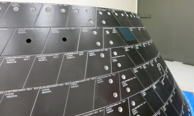 Two one-inch-wide holes have been drilled into tiles on Orion’s back shell to simulate micrometeoroid orbital debris damage . Sensors on the vehicle will record how high temperatures climb inside the hole during Orion’s return through Earth’s atmosphere following its first flight in December. The da Image Credit: NASA Two one-inch-wide holes have been drilled into tiles on Orion’s back shell to simulate micrometeoroid orbital debris damage . Sensors on the vehicle will record how high temperatures climb inside the hole during Orion’s return through Earth’s atmosphere following its first flight in December. The da Image Credit: NASA