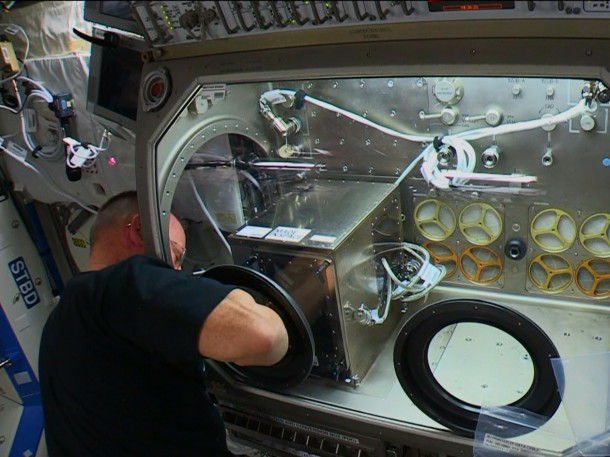 Commander Barry WIlmore works on Monday to install a 3D printer inside the Destiny laboratory’s Microgravity Science Glovebox. Credit: NASA TV Commander Barry WIlmore works on Monday to install a 3D printer inside the Destiny laboratory’s Microgravity Science Glovebox. Credit: NASA TV