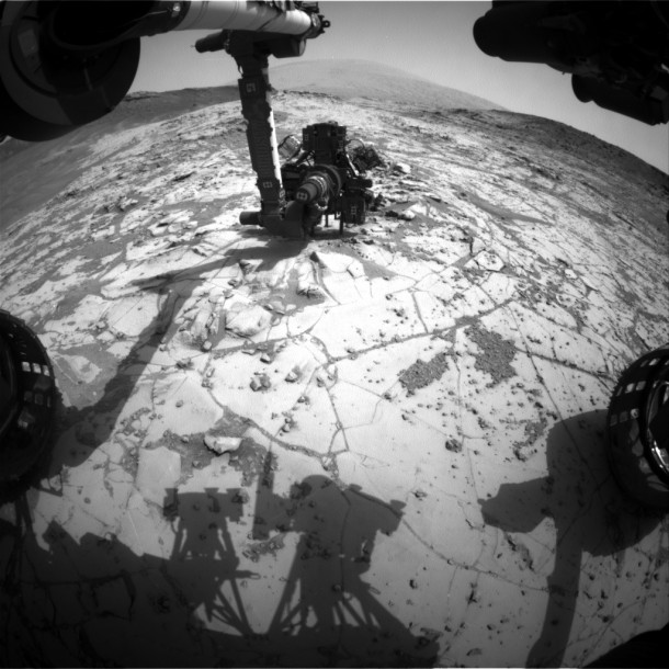 This view from the wide-angle Hazard Avoidance Camera on the front of NASA's Curiosity Mars Rover shows the rover's drill in position for a mini-drill test to assess whether a rock target called "Mojave" is appropriate for full-depth drilling to collect a sample. It was taken on Jan. 13, 2015. Image Credit: NASA/JPL-Caltech This view from the wide-angle Hazard Avoidance Camera on the front of NASA's Curiosity Mars Rover shows the rover's drill in position for a mini-drill test to assess whether a rock target called "Mojave" is appropriate for full-depth drilling to collect a sample. It was taken on Jan. 13, 2015. Image Credit: NASA/JPL-Caltech