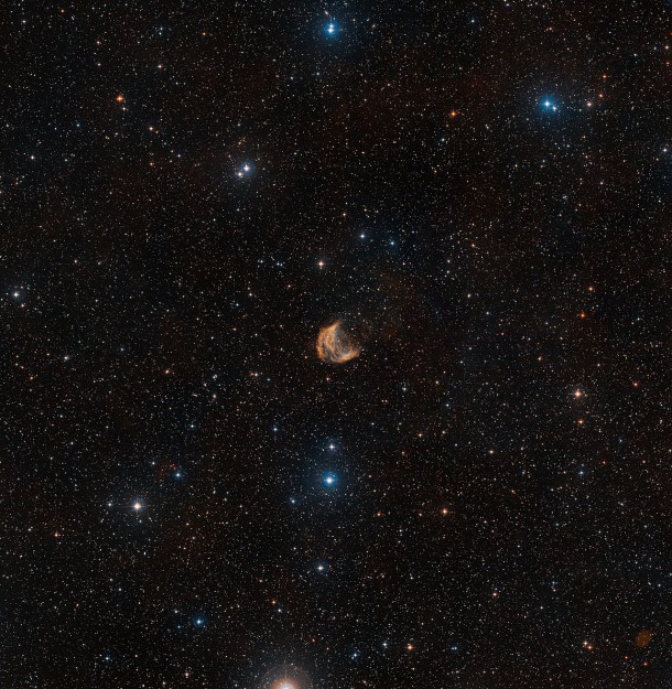This wide-field view shows the sky around the large but faint planetary nebula known as the Medusa Nebula. The full extent of the object can be seen, as well as many faint stars and, far beyond them, numerous distant galaxies.This picture was created from images forming part of the Digitized Sky Survey 2. Credit: ESO/Digitized Sky Survey 2 This wide-field view shows the sky around the large but faint planetary nebula known as the Medusa Nebula. The full extent of the object can be seen, as well as many faint stars and, far beyond them, numerous distant galaxies.This picture was created from images forming part of the Digitized Sky Survey 2. Credit: ESO/Digitized Sky Survey 2