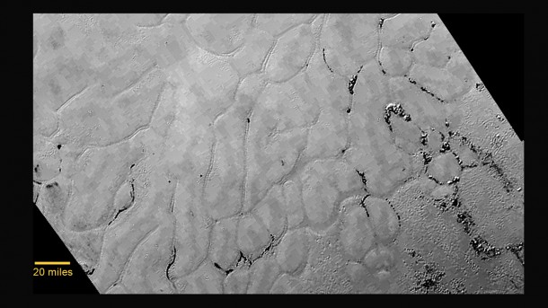 In the center left of Pluto’s vast heart-shaped feature – informally named “Tombaugh Regio” - lies a vast, craterless plain that appears to be no more than 100 million years old, and is possibly still being shaped by geologic processes. This frozen region is north of Pluto’s icy mountains and has been informally named Sputnik Planum (Sputnik Plain), after Earth’s first artificial satellite. The surface appears to be divided into irregularly-shaped segments that are ringed by narrow troughs. Features that appear to be groups of mounds and fields of small pits are also visible. This image was acquired by the Long Range Reconnaissance Imager (LORRI) on July 14 from a distance of 48,000 miles (77,000 kilometers). Features as small as one-half mile (1 kilometer) across are visible. The blocky appearance of some features is due to compression of the image. Credits: NASA/JHUAPL/SWRI In the center left of Pluto’s vast heart-shaped feature – informally named “Tombaugh Regio” - lies a vast, craterless plain that appears to be no more than 100 million years old, and is possibly still being shaped by geologic processes. This frozen region is north of Pluto’s icy mountains and has been informally named Sputnik Planum (Sputnik Plain), after Earth’s first artificial satellite. The surface appears to be divided into irregularly-shaped segments that are ringed by narrow troughs. Features that appear to be groups of mounds and fields of small pits are also visible. This image was acquired by the Long Range Reconnaissance Imager (LORRI) on July 14 from a distance of 48,000 miles (77,000 kilometers). Features as small as one-half mile (1 kilometer) across are visible. The blocky appearance of some features is due to compression of the image. Credits: NASA/JHUAPL/SWRI