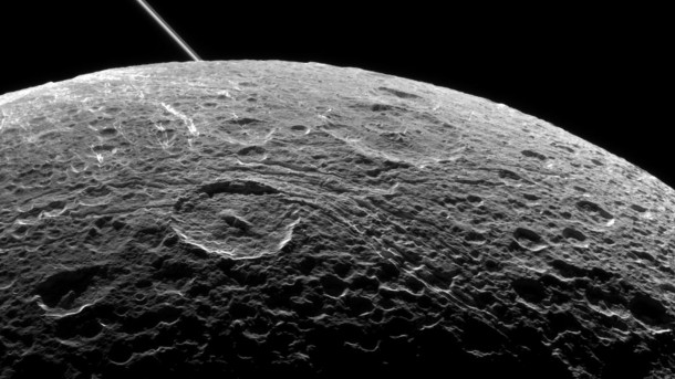 A view of Saturn's moon Dione captured by NASA's Cassini spacecraft during a close flyby on June 16, 2015. The diagonal line near upper left is the rings of Saturn, in the distance. Image credit: NASA/JPL-Caltech/Space Science Institute A view of Saturn's moon Dione captured by NASA's Cassini spacecraft during a close flyby on June 16, 2015. The diagonal line near upper left is the rings of Saturn, in the distance. Image credit: NASA/JPL-Caltech/Space Science Institute