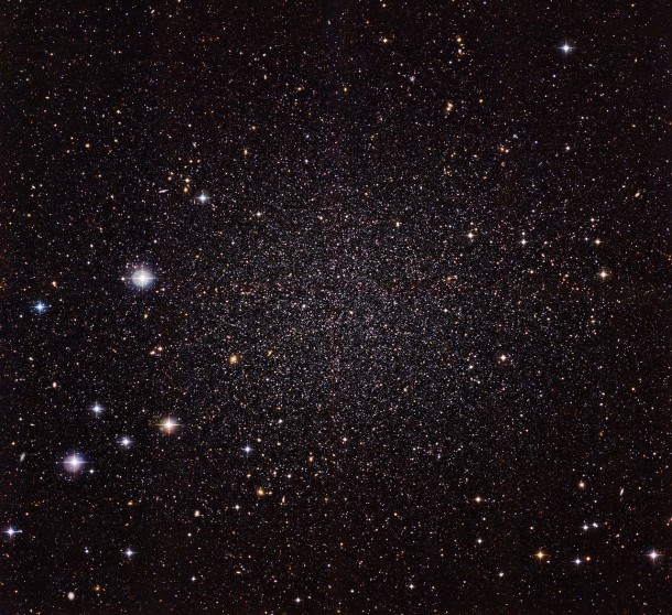 The Sculptor Dwarf Galaxy, pictured in a new image from the Wide Field Imager camera, installed on the 2.2-metre MPG/ESO telescope at ESO’s La Silla Observatory, is a close neighbour of our galaxy, the Milky Way. Despite their proximity, both galaxies have very distinct histories and characters. This galaxy is much smaller, fainter and older than the Milky Way and appears here as a cloud of faint stars filling most of the picture. Many other much more distant galaxies can be seen shining right through the sparse stars of the Sculptor Dwarf. Credit: ESO The Sculptor Dwarf Galaxy, pictured in a new image from the Wide Field Imager camera, installed on the 2.2-metre MPG/ESO telescope at ESO’s La Silla Observatory, is a close neighbour of our galaxy, the Milky Way. Despite their proximity, both galaxies have very distinct histories and characters. This galaxy is much smaller, fainter and older than the Milky Way and appears here as a cloud of faint stars filling most of the picture. Many other much more distant galaxies can be seen shining right through the sparse stars of the Sculptor Dwarf. Credit: ESO