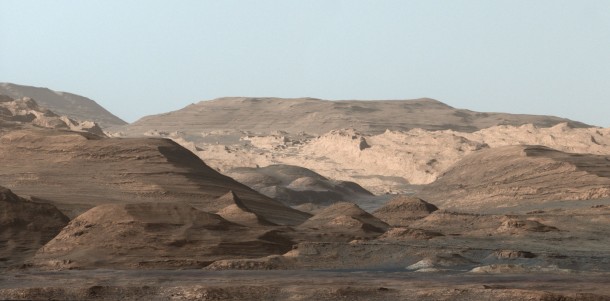 This composite image looking toward the higher regions of Mount Sharp was taken on September 9, 2015, by NASA's Curiosity rover. In the foreground -- about 2 miles (3 kilometers) from the rover -- is a long ridge teeming with hematite, an iron oxide. Credits: NASA/JPL-Caltech/MSSS This composite image looking toward the higher regions of Mount Sharp was taken on September 9, 2015, by NASA's Curiosity rover. In the foreground -- about 2 miles (3 kilometers) from the rover -- is a long ridge teeming with hematite, an iron oxide. Credits: NASA/JPL-Caltech/MSSS