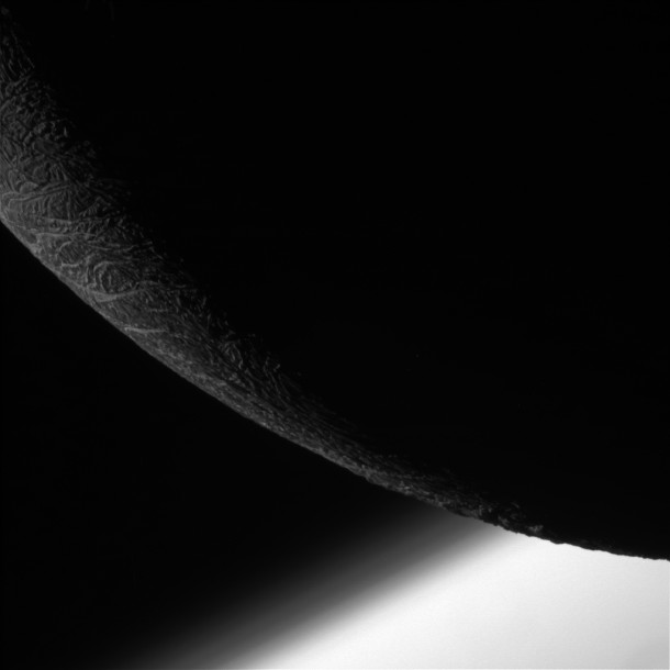 NASA's Cassini spacecraft paused during its final close flyby of Enceladus to focus on the icy moon's craggy, dimly lit limb, with the planet Saturn beyond. NASA's Cassini spacecraft paused during its final close flyby of Enceladus to focus on the icy moon's craggy, dimly lit limb, with the planet Saturn beyond.