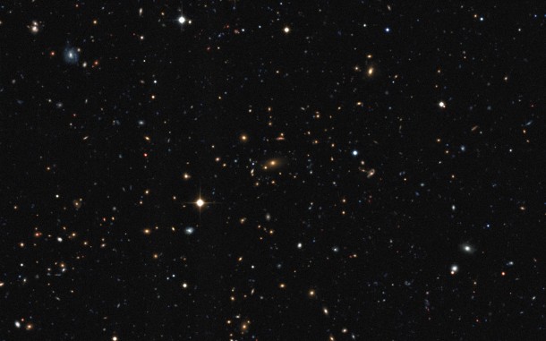 This distant cluster of galaxies was discovered by the XXL survey. It was found by its telltale X-ray emission coming from hot gas, which was detected by ESA's XMM-Newton satellite. The distances to individual galaxies were found using ESO and other telescopes, to allow a three-dimensional view of the distribution of galaxy clusters to be determined. This image was obtained using the Canada France Hawaii Telescope. Credit: XXL consortium/Canada France Hawaii Telescope This distant cluster of galaxies was discovered by the XXL survey. It was found by its telltale X-ray emission coming from hot gas, which was detected by ESA's XMM-Newton satellite. The distances to individual galaxies were found using ESO and other telescopes, to allow a three-dimensional view of the distribution of galaxy clusters to be determined. This image was obtained using the Canada France Hawaii Telescope. Credit: XXL consortium/Canada France Hawaii Telescope