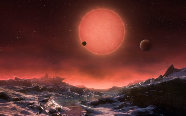 This artist’s impression shows an imagined view from the surface one of the three planets orbiting an ultracool dwarf star just 40 light-years from Earth that were discovered using the TRAPPIST telescope at ESO’s La Silla Observatory. These worlds have sizes and temperatures similar to those of Venus and Earth and are the best targets found so far for the search for life outside the Solar System. They are the first planets ever discovered around such a tiny and dim star. In this view one of the inner planets is seen in transit across the disc of its tiny and dim parent star. Credit: ESO/M. Kornmesser This artist’s impression shows an imagined view from the surface one of the three planets orbiting an ultracool dwarf star just 40 light-years from Earth that were discovered using the TRAPPIST telescope at ESO’s La Silla Observatory. These worlds have sizes and temperatures similar to those of Venus and Earth and are the best targets found so far for the search for life outside the Solar System. They are the first planets ever discovered around such a tiny and dim star. In this view one of the inner planets is seen in transit across the disc of its tiny and dim parent star. Credit: ESO/M. Kornmesser