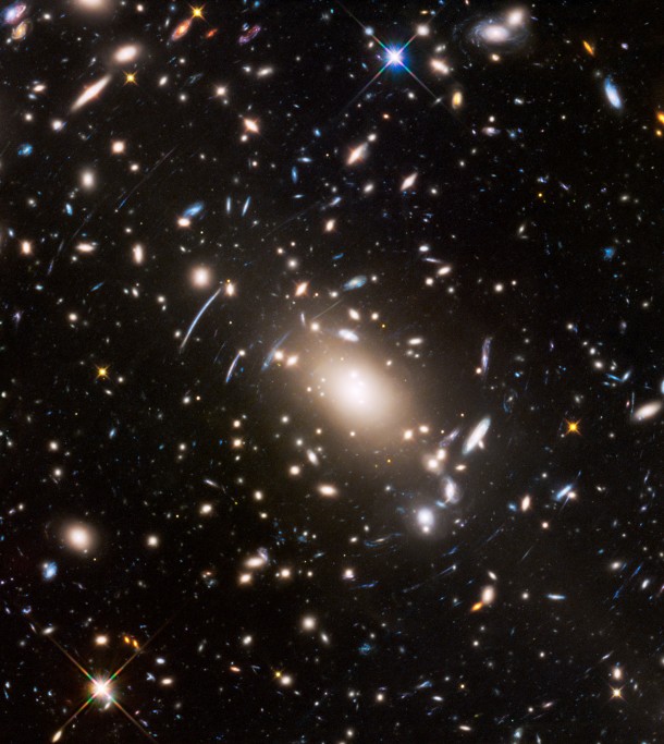 This view of a massive cluster of galaxies unveils a very cluttered-looking universe filled with galaxies near and far. Some are distorted like a funhouse mirror through a "space warp" phenomenon first predicted by Einstein a century ago. Credits: NASA, ESA, and J. Lotz (STScI) This view of a massive cluster of galaxies unveils a very cluttered-looking universe filled with galaxies near and far. Some are distorted like a funhouse mirror through a "space warp" phenomenon first predicted by Einstein a century ago. Credits: NASA, ESA, and J. Lotz (STScI)
