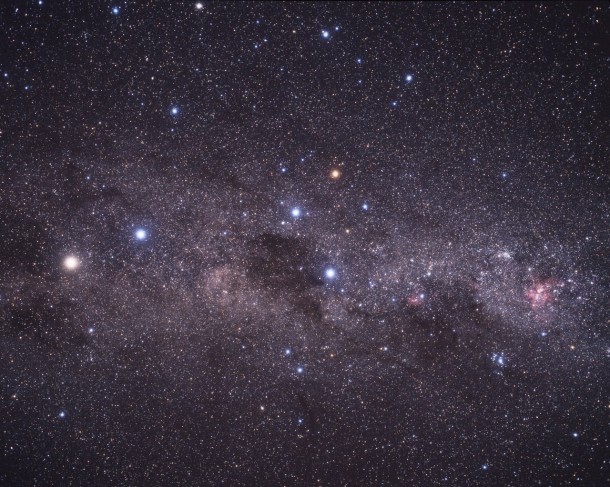 This wide-field image shows the Milky Way stretching across the southern sky. The beautiful Carina Nebula (NGC 3372) is seen at the right of the image glowing in red. It is within this spiral arm of our Milky Way that the bright star cluster NGC 3603 resides. At the centre of the image is the constellation of Crux (The Southern Cross). The bright yellow/white star at the left of the image is Alpha Centauri, in fact a system of three stars, at a distance of about 4.4 light-years from Earth. The star Alpha Centauri C, Proxima Centauri, is the closest star to the Solar System. Credit: A. Fujii This wide-field image shows the Milky Way stretching across the southern sky. The beautiful Carina Nebula (NGC 3372) is seen at the right of the image glowing in red. It is within this spiral arm of our Milky Way that the bright star cluster NGC 3603 resides. At the centre of the image is the constellation of Crux (The Southern Cross). The bright yellow/white star at the left of the image is Alpha Centauri, in fact a system of three stars, at a distance of about 4.4 light-years from Earth. The star Alpha Centauri C, Proxima Centauri, is the closest star to the Solar System. Credit: A. Fujii