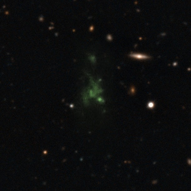 This image shows one of the largest known single objects in the Universe, the Lyman-alpha blob LAB-1. This picture is a composite of two different images taken with the FORS instrument on the Very Large Telescope (VLT) — a wider image showing the surrounding galaxies and a much deeper observation of the blob itself at the centre made to detect its polarisation. The intense Lyman-alpha ultraviolet radiation from the blob appears green after it has been stretched by the expansion of the Universe during its long journey to Earth. These new observations show for the first time that the light from this object is polarised. This means that the giant "blob" must be powered by galaxies embedded within the cloud. Credit: ESO/M. Hayes This image shows one of the largest known single objects in the Universe, the Lyman-alpha blob LAB-1. This picture is a composite of two different images taken with the FORS instrument on the Very Large Telescope (VLT) — a wider image showing the surrounding galaxies and a much deeper observation of the blob itself at the centre made to detect its polarisation. The intense Lyman-alpha ultraviolet radiation from the blob appears green after it has been stretched by the expansion of the Universe during its long journey to Earth. These new observations show for the first time that the light from this object is polarised. This means that the giant "blob" must be powered by galaxies embedded within the cloud. Credit: ESO/M. Hayes