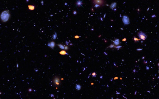 A trove of galaxies, rich in carbon monoxide (indicating star-forming potential) were imaged by ALMA (orange) in the Hubble Ultra Deep Field. The blue features are galaxies imaged by Hubble. This image is based on the very deep ALMA survey by Manuel Aravena, Fabian Walter and colleagues, covering about one sixth of the full HUDF area. Credit: B. Saxton (NRAO/AUI/NSF); ALMA (ESO/NAOJ/NRAO); NASA/ESA Hubble A trove of galaxies, rich in carbon monoxide (indicating star-forming potential) were imaged by ALMA (orange) in the Hubble Ultra Deep Field. The blue features are galaxies imaged by Hubble. This image is based on the very deep ALMA survey by Manuel Aravena, Fabian Walter and colleagues, covering about one sixth of the full HUDF area. Credit: B. Saxton (NRAO/AUI/NSF); ALMA (ESO/NAOJ/NRAO); NASA/ESA Hubble