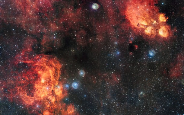 This spectacular image from the VLT Survey Telescope shows the Cat’s Paw Nebula (NGC 6334, upper right) and the Lobster Nebula (NGC 6357, lower left). These dramatic objects are regions of active star formation where the hot young stars are causing the surrounding hydrogen gas to glow red. The very rich field of view also includes dark clouds of dust. With around two billion pixels this is one of the largest images ever released by ESO. Note that the circular features in the image around bright stars are not real, they are due to reflections within the optics of the telescope and camera. Credit: ESO This spectacular image from the VLT Survey Telescope shows the Cat’s Paw Nebula (NGC 6334, upper right) and the Lobster Nebula (NGC 6357, lower left). These dramatic objects are regions of active star formation where the hot young stars are causing the surrounding hydrogen gas to glow red. The very rich field of view also includes dark clouds of dust. With around two billion pixels this is one of the largest images ever released by ESO. Note that the circular features in the image around bright stars are not real, they are due to reflections within the optics of the telescope and camera. Credit: ESO