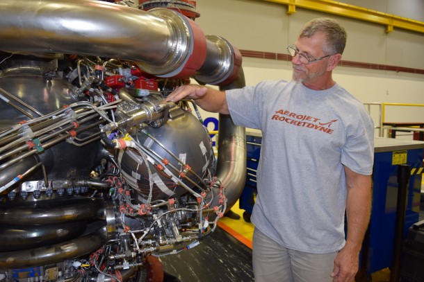 Owen Brayson, an instrumentation technician for NASA's RS-25 prime contractor Aerojet Rocketdyne, exhibits the pogo accumulator assembly, NASA's largest 3-D-printed rocket engine component tested in the restart of RS-25 production, on Engine 0528. The engine was successfully tested Dec. 13. Credits: Aerojet Rocketdyne Owen Brayson, an instrumentation technician for NASA's RS-25 prime contractor Aerojet Rocketdyne, exhibits the pogo accumulator assembly, NASA's largest 3-D-printed rocket engine component tested in the restart of RS-25 production, on Engine 0528. The engine was successfully tested Dec. 13. Credits: Aerojet Rocketdyne