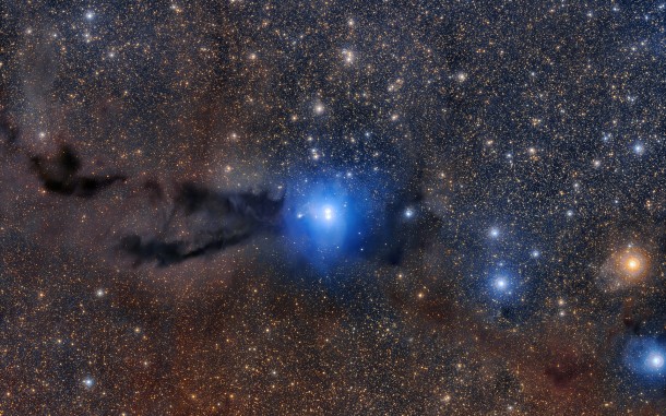 A dark cloud of cosmic dust snakes across this spectacular wide field image, illuminated by the brilliant light of new stars. This dense cloud is a star-forming region called Lupus 3, where dazzlingly hot stars are born from collapsing masses of gas and dust. This image was created from images taken using the VLT Survey Telescope and the MPG/ESO 2.2-metre telescope and is the most detailed image taken so far of this region. Credit: ESO/R. Colombari A dark cloud of cosmic dust snakes across this spectacular wide field image, illuminated by the brilliant light of new stars. This dense cloud is a star-forming region called Lupus 3, where dazzlingly hot stars are born from collapsing masses of gas and dust. This image was created from images taken using the VLT Survey Telescope and the MPG/ESO 2.2-metre telescope and is the most detailed image taken so far of this region. Credit: ESO/R. Colombari