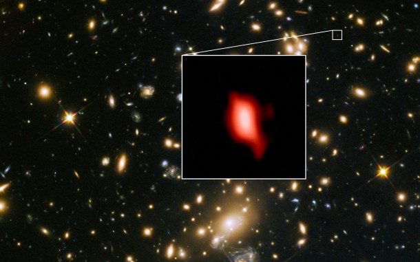 This image shows the galaxy cluster MACS J1149.5+2223 taken with the NASA/ESA Hubble Space Telescope; the inset image is the very distant galaxy MACS1149-JD1, seen as it was 13.3 billion years ago and observed with ALMA. Here, the oxygen distribution detected with ALMA is depicted in red. Credit: ALMA (ESO/NAOJ/NRAO), NASA/ESA Hubble Space Telescope, W. Zheng (JHU), M. Postman (STScI), the CLASH Team, Hashimoto et al. This image shows the galaxy cluster MACS J1149.5+2223 taken with the NASA/ESA Hubble Space Telescope; the inset image is the very distant galaxy MACS1149-JD1, seen as it was 13.3 billion years ago and observed with ALMA. Here, the oxygen distribution detected with ALMA is depicted in red. Credit: ALMA (ESO/NAOJ/NRAO), NASA/ESA Hubble Space Telescope, W. Zheng (JHU), M. Postman (STScI), the CLASH Team, Hashimoto et al.