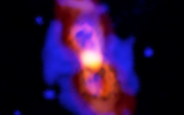   Composite image of CK Vulpeculae, the remains of a double-star collision. This impact launched radioactive molecules into the space, as can be seen in the orange structure with two lobes in the center. This is an ALMA image of 27 aluminum monofluoride, but the rare isotropic version of the AIF resides in the same region. The red and diffuse image is an ALMA image of the wider dust in the area. Blue is an optical datum of the Gemini Observatory. Credit: ALMA (ESO / NAOJ / NRAO), T. Kamiński; Gemini, NOAO / AURA / NSF; NRAO / AUI / NSF, B. Saxton 